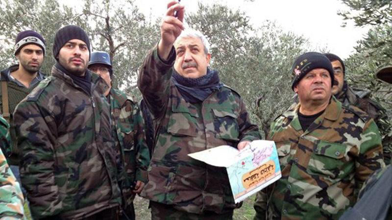 معراج أورال المعروف بعلي كيالي يرتدي الزي العسكري وسط مجموعة من المسلحين في صورة أرشيفية